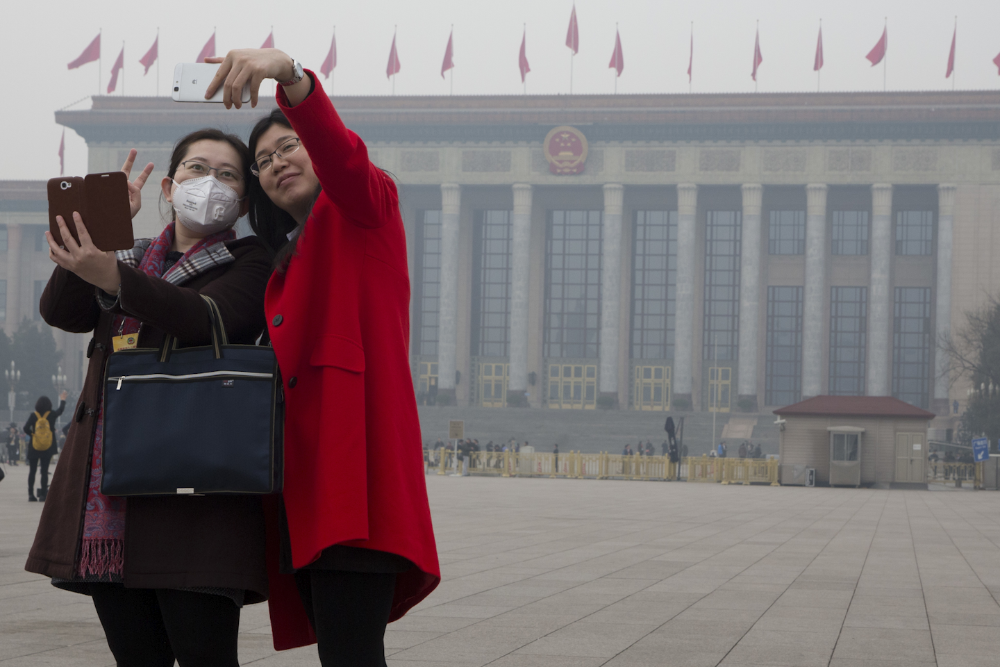 In this March 3, 2016 photo, women pose for selfies during a polluted day at the opening session of the Chinese People's Political Consultative Conference (CPPCC) in Beijing's Great Hall of the People. (AP Photo/Ng Han Guan)