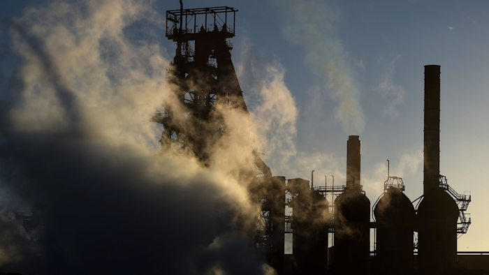 The sun sets as smoke and steam rises from the Tata steel plant in Port Talbot, Wales, Wednesday March 30, 2016. (Andrew Matthews / PA via AP)