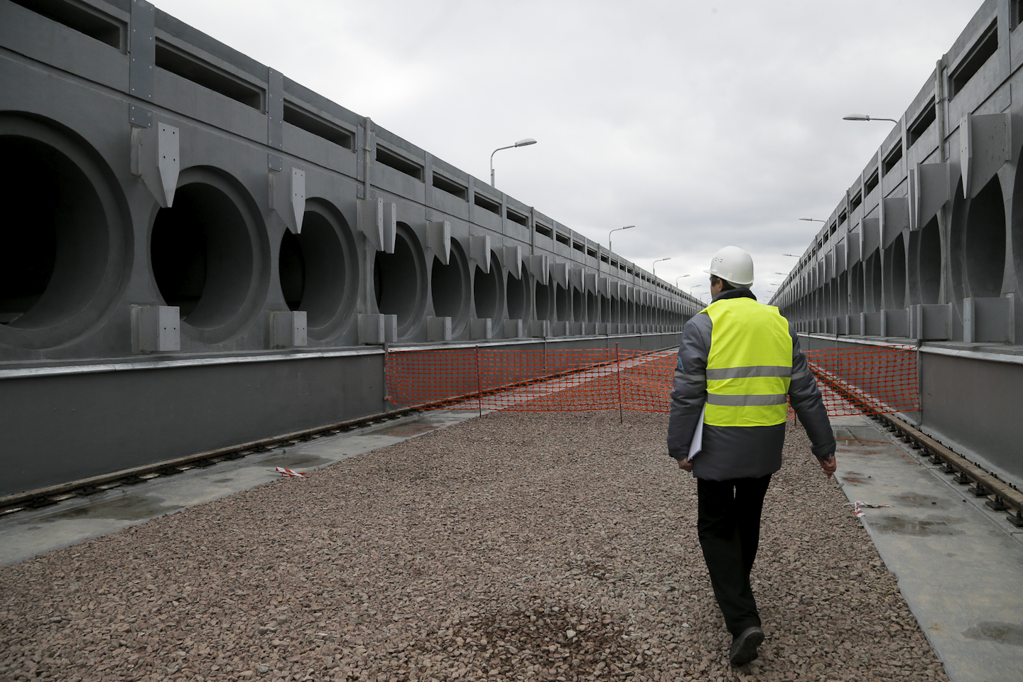 In this photo taken Wednesday, March 23, 2016, a worker passes by a storage facility under construction for nuclear waste at the Chernobyl nuclear power plant in Chernobyl, Ukraine. When a new structure will be installed over the sarcophagus and reactor building, robotic machinery inside the structure will begin dismantling the sarcophagus and the destroyed reactor and gather up the wastes to be transported to a nearby storage facility. Under current plans, that process is expected to begin in 2017. (AP Photo/Efrem Lukatsky)