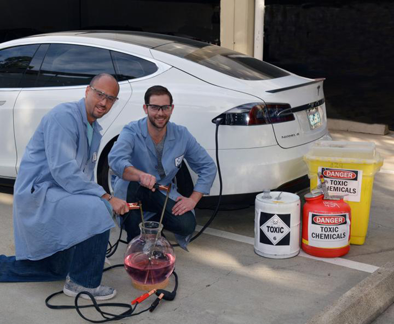 Scripps Research Institute chemists Phil Baran (left) and Evan Horn pose in front of an electric car, whose principles of sustainable transport pertain to the sustainable chemistry in the Baran lab's new electrochemical allylic oxidation reaction, which eliminates toxic chemicals from a widely employed chemical process.
