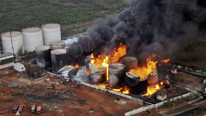 Flames rise and black smoke fills the air after a fire broke out at the Biomax Fuels Ltd. near Vishakhapatnam, a port city in Andhra Pradesh state, India, Wednesday, April 27, 2016. The biofuel manufacturing plant caught fire Tuesday night, triggering explosions in biodiesel tanks and forcing around 150 workers to flee the facility, officials said Wednesday.(Press Trust of India via AP)