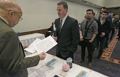 In this April 22, 2015 file photo, Ralph Logan, general manager of Microtrain, left, speaks with James Smith who is seeking employment during a National Career Fairs job fair in Chicago. U.S. employers notched another solid month of hiring in March by adding 215,000 jobs, driven by large gains in the construction, retail and health care industries. Despite the jump, the Labor Department said Friday, April 1, 2016 that the unemployment rate ticked up to 5 percent from 4.9 percent. (AP Photo/M. Spencer Green, File)
