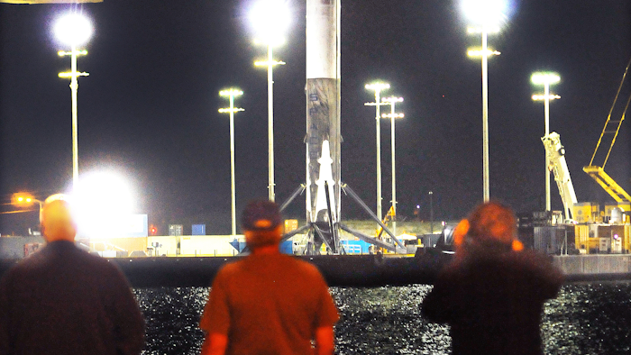 People watch as SpaceX Falcon 9 booster returns to Port Canaveral, Fla., early Tuesday, April 12, 2016. (Craig Rubadoux/Florida Today via AP)