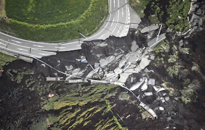 In this aerial photo, the landslide caused by the earthquake disrupts the road in Minamiaso town, Kumamoto prefecture, southern Japan Saturday, April 16, 2016. (Kyodo News via AP)