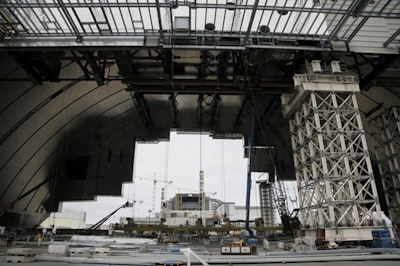 Workers build an arch-shape confinement that will be moved on rails over the sarcophagus and reactor building damaged by explosion, at the Chernobyl nuclear power plant. (AP Photo/Efrem Lukatsky)