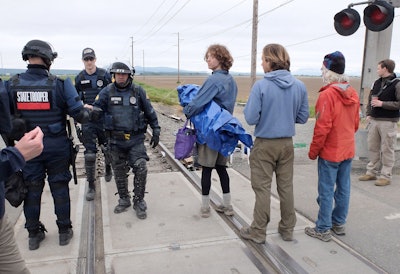 Authorities wrap up clearing the railroad tracks of protesters Sunday, May 15, 2016, west of Burlington, Wash. Dozens of climate activists were arrested Sunday morning, after a two-day shutdown. About 150 people spent the night in tents and sleeping bags on the tracks near two refineries in northwest Washington, according to BNSF Railway spokesman Gus Melonas. (Scott Terrell/Skagit Valley Herald via AP)