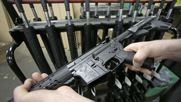 In this April 10, 2013 file photo, craftsman Veetek Witkowski holds a newly assembled AR-15 rifle at the Stag Arms company in New Britain, Conn, Wednesday, April 10, 2013. Stag was fined $500,000 and Mark Malkowski, the former owner of a company, was fined $100,000 for violating federal firearms laws. (AP Photo/Charles Krupa)