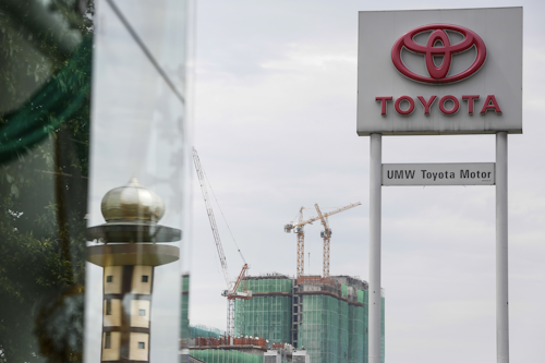 In this Tuesday, May 24, 2016 photo, a UMW Toyota signage is seen against a construction site at a sales showroom in Kuala Lumpur, Malaysia. Japanese automaker Toyota Motor Corp. said it will build a second factory in Malaysia as part of expansion to meet rising local demand. (AP Photo/Joshua Paul)