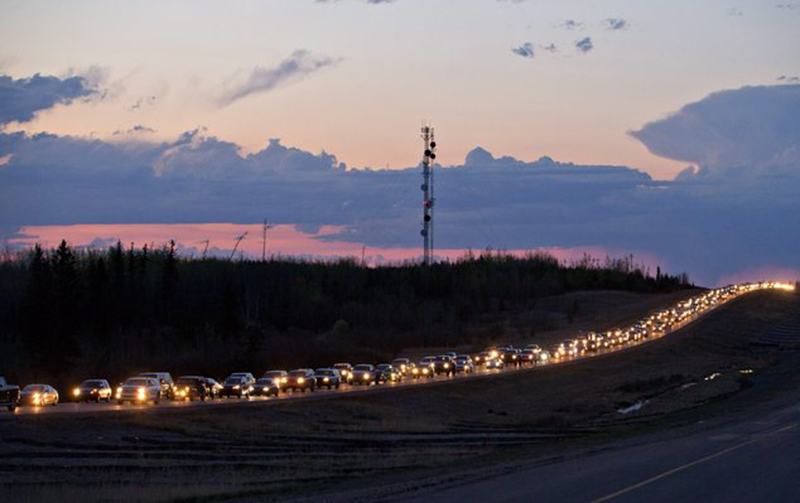 More than 80,000 residents were ordered to flee as a wildfire moved into the city, destroying whole neighborhoods. (Jason Franson/The Canadian Press via AP)