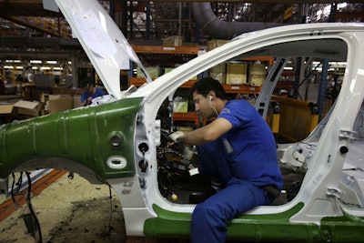 An Iranian car worker assembles a car at the state-run Iran Khodro automobile manufacturing plant just outside Tehran, Iran. (AP Photo/Vahid Salemi, File)