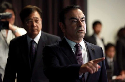 Nissan Motor Co. President and CEO Carlos Ghosn, right, and Mitsubishi Motors Corp. Chairman and CEO Osamu Masuko, left, walk in the venue of their joint press conference at the Nissan headquarters in Yokohama, near Tokyo. (AP Photo/Eugene Hoshiko)