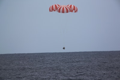 A SpaceX capsule containing science samples from NASA's one-year space station resident, approaches the Pacific Ocean, a few hundred miles off the Southern California coast, Wednesday, May 11, 2016. (SpaceX via AP)