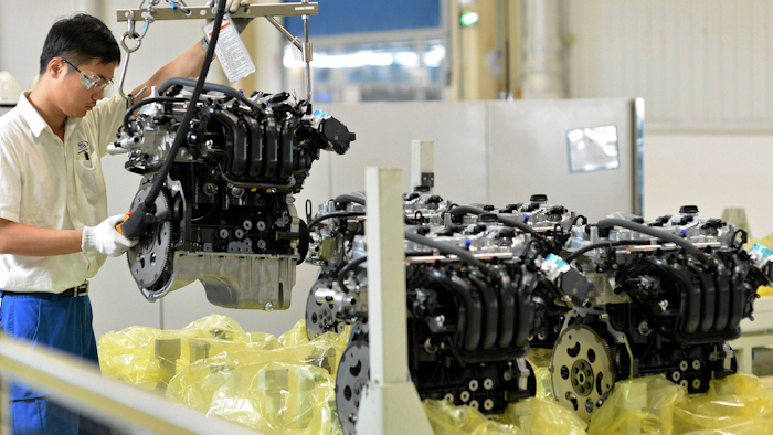 A worker arranges engine blocks at the General Motors assembly plant in Wuhan in central China's Hubei province. (Chinatopix via AP) CHINA OUT