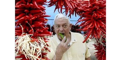 FILE - In this Aug. 30, 2008 file photo, framed by ristras, John Trewitt bites into a pod of fresh Hatch green chile, at the Hatch Chile Festival in Hatch, N.M. A federal appeals court is siding with an association of green chile growers in the Hatch Valley of southern New Mexico in a dispute over what food can be fairly labeled with the renowned Hatch name. The U.S. 10th Circuit Court of Appeals on Friday, June 17, 2016, ruled in favor of the Hatch Chile Association and allied Albuquerque food distributor El Encanto in their efforts to subpoena records that may indicate whether a rival's products contain purely Hatch-grown chile as marketing suggests. (Norm Dettlaff/The Las Cruces Sun-News via AP, File)