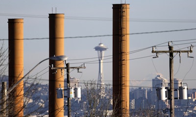 In this Feb. 25, 2016 file photo, the Space Needle is seen in view of still standing but now defunct stacks at the Nucor Steel plant in Seattle. The state is releasing its second take of a proposed rule to require the state's largest polluters to reduce their carbon pollution in an effort to tackle climate change. The Department of Ecology withdrew a rule in February to make substantive changes. The measure released Wednesday, June 1 is a key piece in Gov. Jay Inslee's efforts to tackle climate change and reflects other efforts in California and the Northeast. (AP Photo/Elaine Thompson, file)