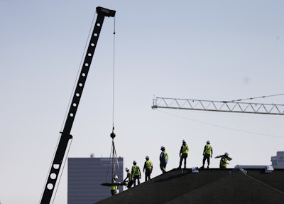 In this Wednesday, March 23, 2016, photo, construction workers unload supplies off a hoisted pallet on a rooftop in Atlanta. On Tuesday, June 7, 2016, the Labor Department issues revised data on productivity in the first quarter. (AP Photo/David Goldman)