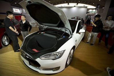In this Monday, April 25, 2016, file photo, visitors gather around a Tesla Model S electric car on display at the Beijing International Automotive Exhibition in Beijing. Tesla Motors is denying allegations that there are safety problems with its vehicle suspensions. The Palo Alto, Calif., company says one of its cars had an abnormal amount of rust on a suspension part, a problem it hasn't seen in any other car. (AP Photo/Mark Schiefelbein, File)