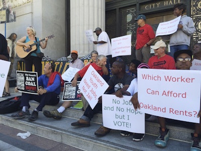 People hold up signs and demonstrate outside City Hall, Monday, June 27, 2016, in Oakland, Calif. A scheduled vote in Northern California is expected to decide whether to ban rail shipments of coal over concerns it would pose a public health or safety hazard. (AP Photo/Janie Har)