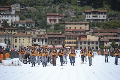 Workers walk on the installation 'The Floating Piers' by Bulgarian-born artist Christo Vladimirov Yavachev known as Christo, on the Lake Iseo, northern Italy (AP Photo/Luca Bruno).