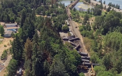 This video image taken from a drone shows an aerial view of crumpled oil tankers lying beside the railroad tracks after a fiery train derailment on June 3 prompted evacuations from the tiny Columbia River Gorge town about 70 miles east of Portland, on Monday, June 6. (Brent Foster via AP)