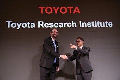 Toyota Motor Corp.'s Executive Technical Advisor Gill Pratt, left, and President Akio Toyoda, right, shake hands during a press conference on artificial intelligence in Tokyo. (AP Photo/Eugene Hoshiko, FIle)