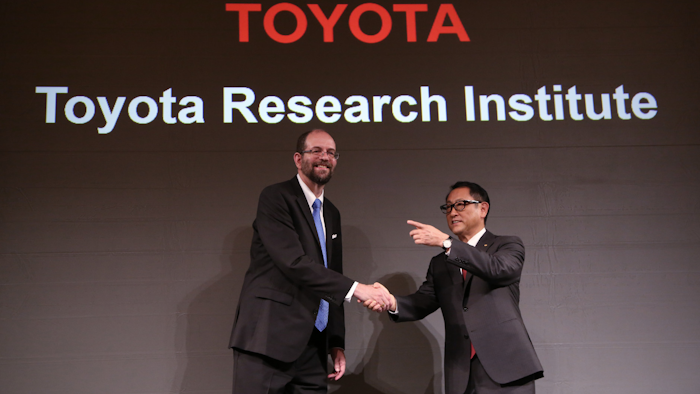 Toyota Motor Corp.'s Executive Technical Advisor Gill Pratt, left, and President Akio Toyoda, right, shake hands during a press conference on artificial intelligence in Tokyo. (AP Photo/Eugene Hoshiko, FIle)