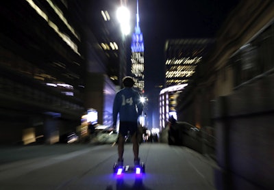 In this Oct. 21, 2015, file photo, a young man rides a hoverboard along a Manhattan street toward the Empire State Building in New York. More than 500,000 hoverboards are being recalled after reports that they can burst into flames. The Consumer Product Safety Commission said Wednesday, July 6, 2016, it has received 99 reports of battery packs in the two-wheel motorized scooters catching fire or exploding that causing burns or property damage. The recalled hoverboards were made by eight companies. (AP Photo/Kathy Willens, File)