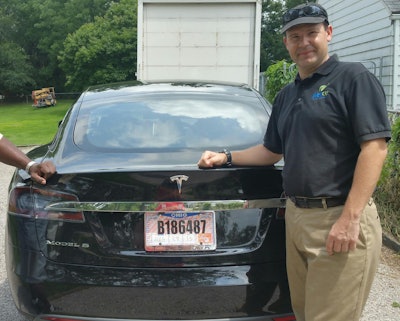 In this 2015 file photo provided by his neighbor, Krista Kitchen, Joshua Brown stands by his new Tesla electric car near his home in Canton, Ohio. Brown died in an accident in Florida on May 7, 2016 in the first fatality from a car using self-driving technology. According to statements by the government and the automaker, his vehicle's cameras didn't make a distinction between the white side of a turning tractor-trailer and the brightly lit sky while failing to automatically activate its brakes. The National Highway Traffic Safety Administration continues to investigate the crash. (Krista Kitchen via AP, File)