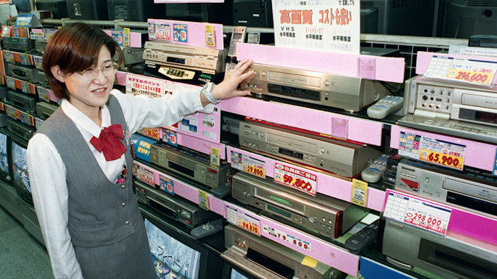 In this Oct. 31, 1998 photo, a salesclerk shows high quality VHS video casette recorders at a home and electrical appliance store in Osaka. (Kyodo News via AP, Japan Out)