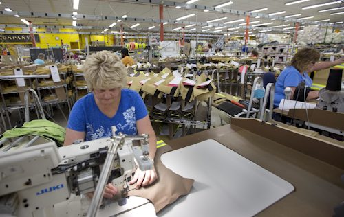 Misty Thurston stitches suits for firefighters at Globe Manufacturing Co. Monday July 25, 2016, in Pittsfield, N.H. New Hampshire has a 2.7 percent unemployment rate, but the state's manufacturing industry is struggling to find enough skilled workers to fill open jobs. Northern New England's rapidly aging population means the problem will only get worse as skilled workers retire and not enough young people are available to replace them.(AP Photo/Jim Cole)