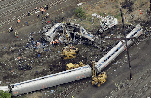 In this Wednesday, May 13, 2015 file photo, emergency personnel work at the scene of a derailment in Philadelphia of an Amtrak train headed to New York. Many commuter and freight railroads have made little progress installing safety technology designed to prevent deadly collisions and derailments despite a mandate from Congress, according to a government report released Wednesday, Aug. 17, 2016. (AP Photo/Patrick Semansky, File)