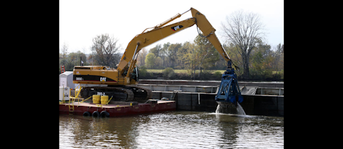 Workers use excavators with environmental clamshell buckets mounted on flat, anchored platforms to dredge the river. The PCB-contaminated sediment is emptied onto 35-foot-wide, 195-foot-long floating barges. (EPA photo)