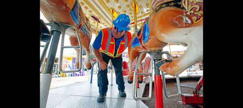 In this Tuesday, Oct. 6, 2015 file photo, amusement device inspector Avery Wheelock inspects the safety pins on a children's merry-go-round at the Mississippi State Fair in Jackson, Miss. (AP Photo/Rogelio V. Solis, File)