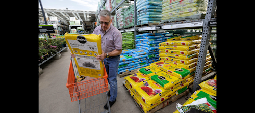 In this Wednesday, May 18, 2016, photo, Joe Russo, of Medway, Mass., puts a bag of potting soil into a cart while shopping at a Home Depot store location, in Bellingham, Mass. The U.S. economy expanded at a sluggish pace this spring as businesses sharply reduced their stockpiles of goods and spent less on new buildings and equipment, according to information released by the Commerce Department, Friday, Aug. 26, 2016. (AP Photo/Steven Senne)