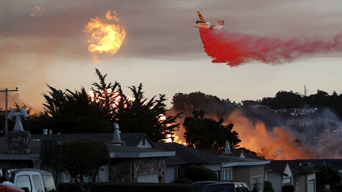 In this Sept. 9, 2010, file photo, a massive fire following a pipeline explosion roars through a mostly residential neighborhood in San Bruno, Calif. In a big victory for Pacific Gas & Electric Co., a judge has cut nearly all of a potential $562 million fine against the giant utility in a criminal case alleging it violated safety regulations before a deadly natural gas pipeline explosion in California and then obstructed investigators. (AP Photo/Jeff Chiu, File)