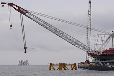 A construction crane works over a foundation installed for a wind turbine by Deepwater Wind off the coast of Block Island, R.I. Deepwater Wind anticipates opening the first U.S. offshore wind farm there in the fall of 2016. (AP Photo/Stephan Savoia, File)