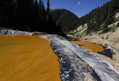 Water flows through a series of sediment retention ponds built to reduce heavy metal and chemical contaminants from the Gold King Mine wastewater accident, in the spillway about 1/4 mile downstream from the mine, outside Silverton, Colo. (AP Photo/Brennan Linsley, File)