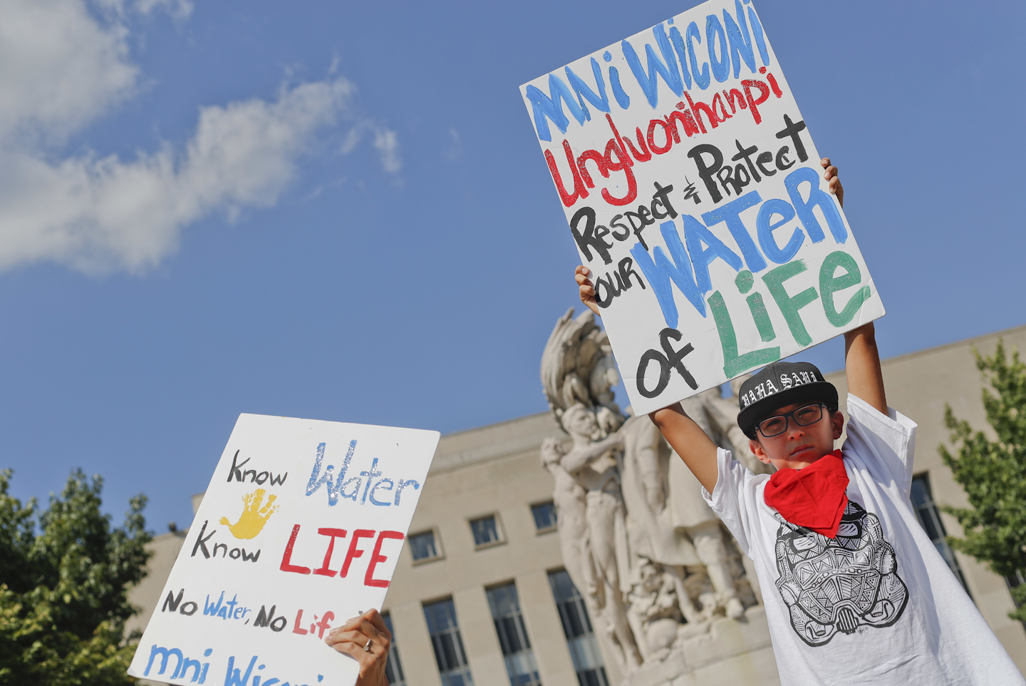 Tusweca Mendoza, 10, of Arlington, Va., originally from Pine Ridge, S.D., holds up a sign outside U.S. District Court in Washington, Tuesday, Sept. 6, 2016, as members of the Standing Rock Sioux Tribe have asked a federal judge to temporarily stop work on parts of the Dakota Access Pipeline to prevent the destruction of sacred and culturally significant sites near Lake Oahe. (AP Photo/Pablo Martinez Monsivais)