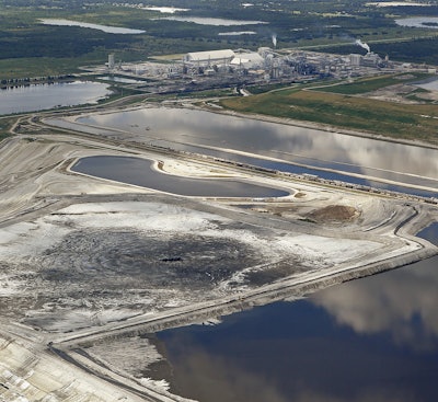 This aerial photo shows a massive sinkhole Friday, Sept. 16, 2016, in Mulberry, Fla., that opened up underneath a gypsum stack at a Mosaic phosphate fertilizer plant. Tens of millions of gallons of reprocessed water from the fertilizer plant in central Florida are likely to have seeped into the Floridan aquifer after the massive sinkhole opened up. Mosaic says it's monitoring groundwater and has found no offsite impact. (Jim Damaske/Tampa Bay Times via AP)