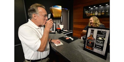 Scott Schwar, left, of Oak Park, Il, orders the first cocktail from Stacy Clark at the new Jim Beam Bourbon Bar located on the grounds of the Jim Beam Distillery, Wednesday, Sept. 14, 2016, in Clermont, Ky. This summer, Kentucky passed legislation allowing distilleries to apply for licences to permit the sale of cocktails by the glass, and Jim Beam was among the first to receive it's license. (AP Photo/Timothy D. Easley)