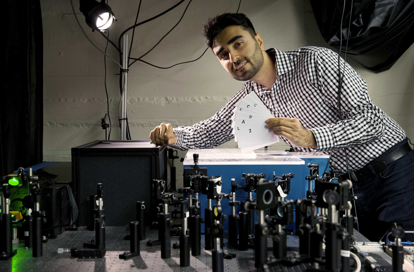 In this Monday, Sept. 12, 2016 photo, Barmak Heshmat poses with his prototype scanning device in a lab at Massachusetts Institute of Technology in Cambridge, Mass. Researchers at MIT have come up with a technology that can read the pages of a book without opening the cover, a development that could help museums better analyze antique books and ancient texts. (AP Photo/Michael Dwyer)