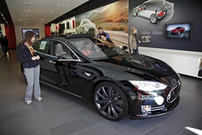 Shoppers check out the Tesla model S at the Tesla showroom at the the Third Street Promenade in Santa Monica, Calif. (AP Photo/Richard Vogel, File)