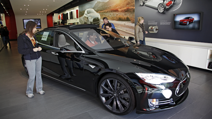 Shoppers check out the Tesla model S at the Tesla showroom at the the Third Street Promenade in Santa Monica, Calif. (AP Photo/Richard Vogel, File)