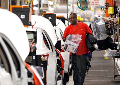 In this April 6, 2016, photograph, a technician carries installation supplies along the assembly line at the Nissan Canton Vehicle Assembly Plant in Canton, Miss. On Wednesday, Oct. 5, 2016, the Commerce Department reports on U.S. factory orders for August. (AP Photo/Rogelio V. Solis)