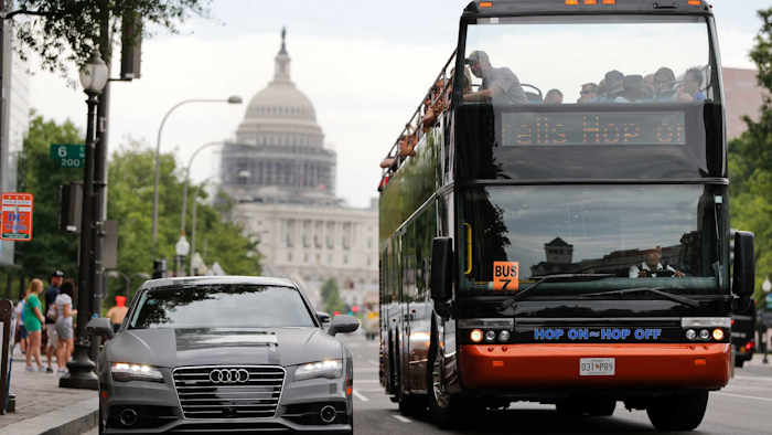 A double decker tour bus drives by an Audi self driving vehicle parked on Pennsylvania Avenue, near the Capitol in Washington. (AP Photo/Pablo Martinez Monsivais)