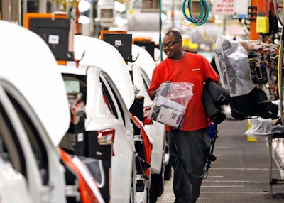 A technician carries installation supplies along the assembly line at the Nissan Canton Vehicle Assembly Plant in Canton, Miss. (AP Photo/Rogelio V. Solis)