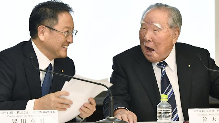 Toyota Motor Corp. President Akio Toyoda, left, and Suzuki Motor Corp. Chairman Osamu Suzuki laugh at each other during a news conference in Tokyo Wednesday, Oct. 12, 2016. (Shigeyuki Inakuma/Kyodo News via AP)