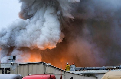 Los Angeles County firefighters watch as an explosions erupts from a commercial fire at a warehouse in Maywood, Calif. (AP Photo/Richard Vogel,File)