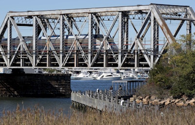 In this Friday, Oct. 14, 2016 photo, an Amtrak Acela train crosses the Connecticut River in Old Lyme, Conn. A plan to speed up Amtrak's high-speed rail corridor from Boston to Washington, D.C., is welcomed by business commuters but finding its strongest opposition in some shoreline towns in Connecticut. (AP Photo/Michael Dwyer)