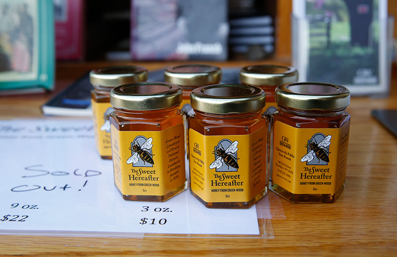 In this Nov. 1, 2016 photo from Brooklyn's Green-Wood cemetery, bottles of locally produced honey, called ''The Sweet Hereafter,' are for sale outside the cemetery's main entrance in New York. The honey is harvested from hives located inside the 478-acre cemetery as part of a program to fight colony collapse disorder among bees, says Green-Wood Manager of Public Engagement and Development John Connolly. 'We're all excited about producing local honey and pleased that we can share it with the public.' The cemetery also hopes the honeybees will cross-pollinate plants and trees (AP Photo/Kathy Willens)